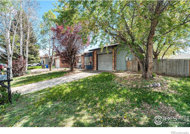 view of yard featuring an attached garage and driveway