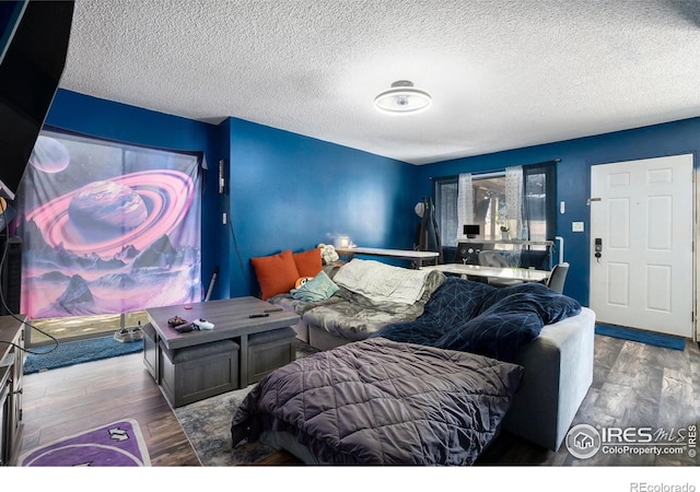 bedroom featuring wood finished floors and a textured ceiling