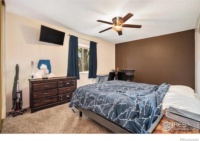 carpeted bedroom with a textured ceiling and a ceiling fan