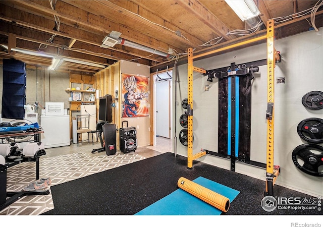 workout room with washing machine and clothes dryer and tile patterned floors