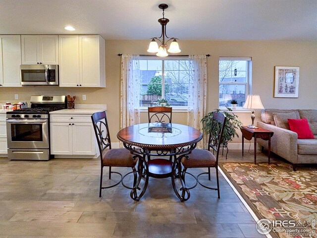 dining area with baseboards, recessed lighting, and a chandelier