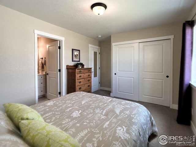 carpeted bedroom with a closet, baseboards, and ensuite bath