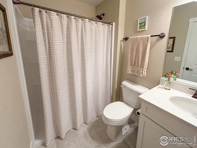 full bathroom with tile patterned flooring, toilet, vanity, and curtained shower