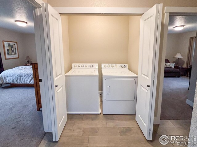 clothes washing area featuring separate washer and dryer and carpet