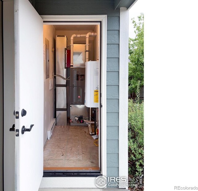 property entrance with water heater and electric panel