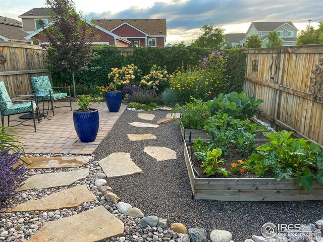 fenced backyard with a garden and a patio