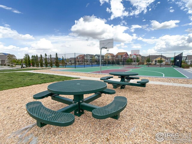 view of sport court featuring community basketball court, fence, and a residential view