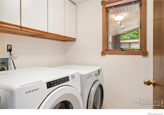 washroom featuring cabinet space and separate washer and dryer