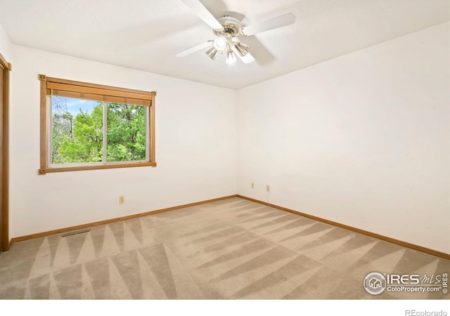 unfurnished room with baseboards, light carpet, and a ceiling fan