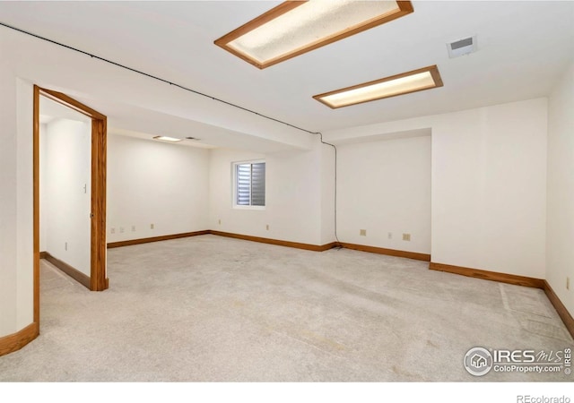 carpeted spare room featuring baseboards