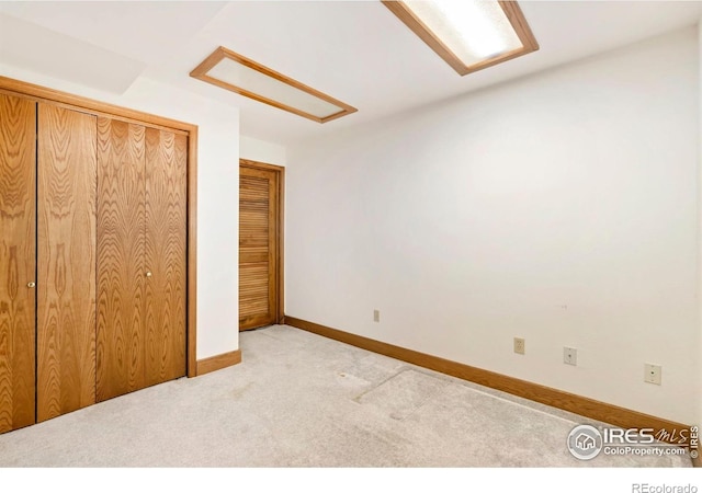 unfurnished bedroom featuring light colored carpet and baseboards