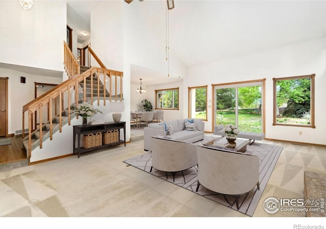 carpeted living room with a towering ceiling, stairs, baseboards, and a chandelier