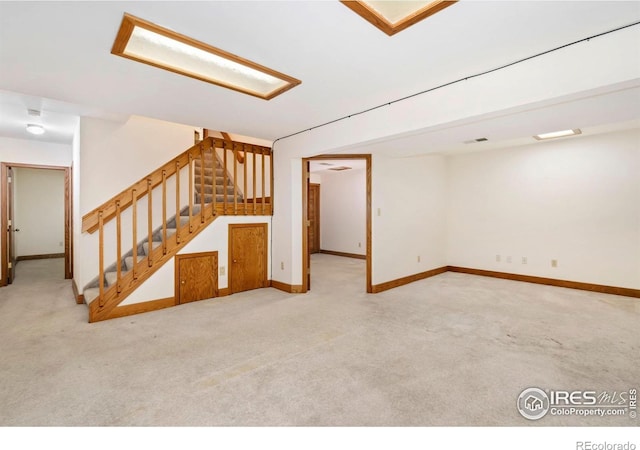 finished basement with carpet floors, baseboards, and stairs