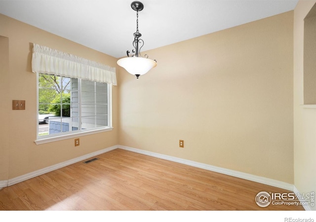 spare room with wood finished floors and baseboards
