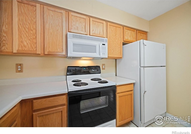 kitchen featuring white appliances, light countertops, and light tile patterned floors