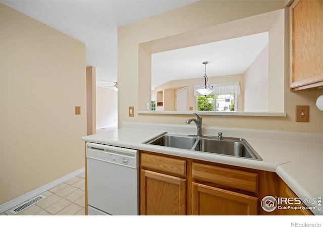 kitchen featuring white dishwasher, a sink, light countertops, light tile patterned floors, and pendant lighting