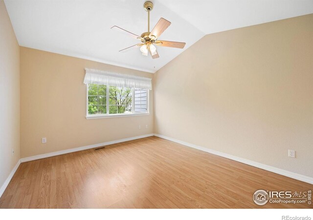 unfurnished room with wood finished floors, vaulted ceiling, baseboards, and ceiling fan