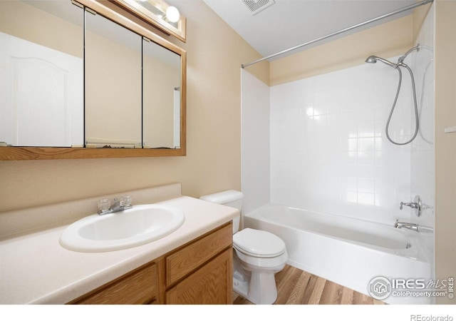 bathroom with toilet, wood finished floors, washtub / shower combination, and vanity