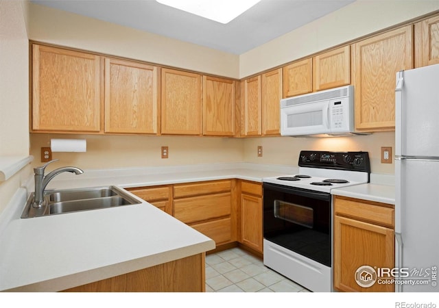 kitchen with white appliances, a sink, light countertops, light tile patterned flooring, and light brown cabinetry
