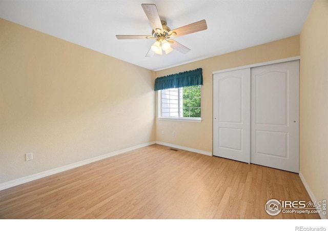 unfurnished bedroom featuring wood finished floors, baseboards, a closet, and ceiling fan