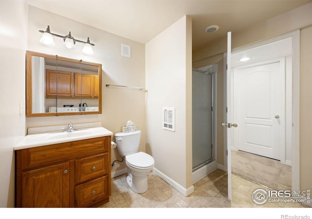 bathroom featuring a stall shower, vanity, baseboards, and toilet