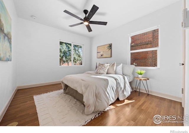 bedroom featuring wood finished floors, baseboards, and a ceiling fan