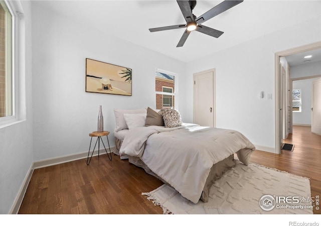 bedroom featuring wood finished floors, baseboards, and a ceiling fan