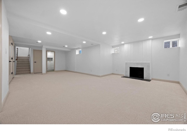 below grade area with recessed lighting, a brick fireplace, baseboards, carpet floors, and stairway
