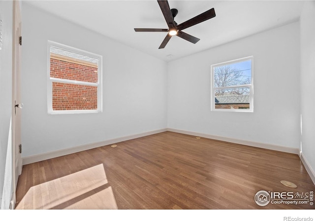 unfurnished room featuring wood finished floors, a ceiling fan, and baseboards