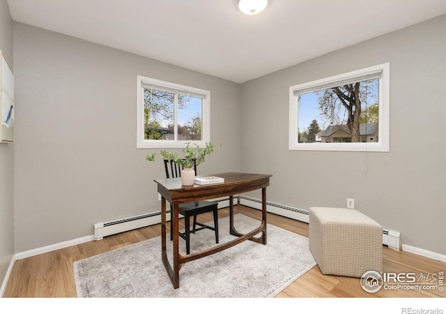 office with plenty of natural light, a baseboard radiator, and wood finished floors