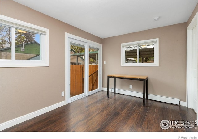 spare room with dark wood-type flooring, baseboards, and plenty of natural light