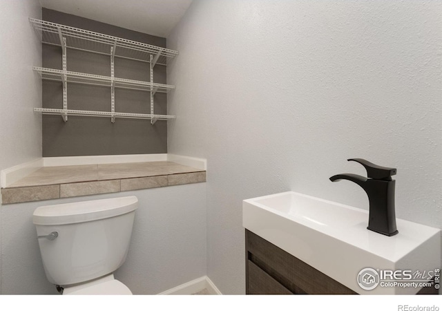 half bath featuring toilet and vanity