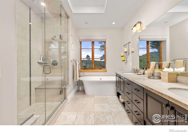 bathroom featuring healthy amount of natural light, a stall shower, double vanity, a freestanding tub, and recessed lighting