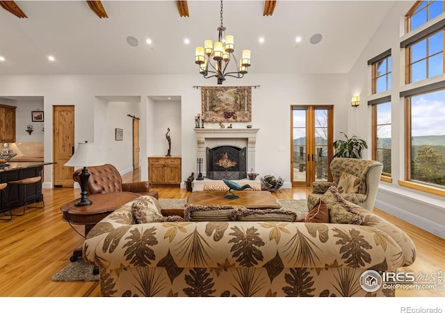 living room featuring a chandelier, light wood-type flooring, healthy amount of natural light, high vaulted ceiling, and recessed lighting