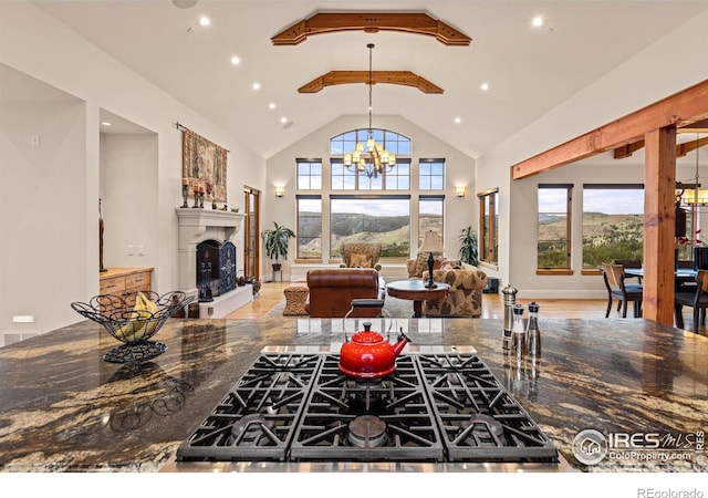 living room with high vaulted ceiling, a chandelier, recessed lighting, and a fireplace with raised hearth