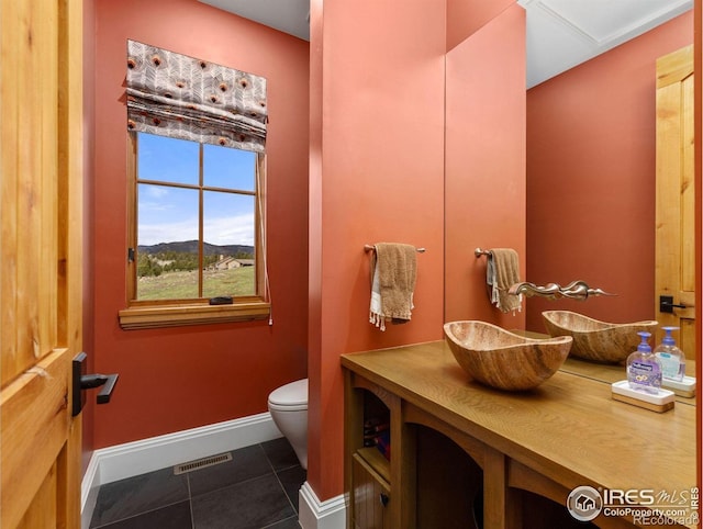 bathroom featuring baseboards, toilet, tile patterned flooring, and vanity