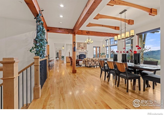 dining space featuring beam ceiling, light wood finished floors, a chandelier, a large fireplace, and recessed lighting