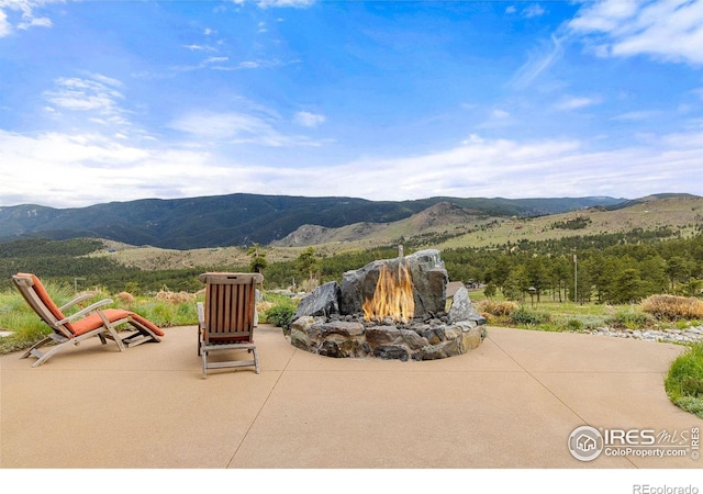 view of patio / terrace featuring a fire pit and a mountain view