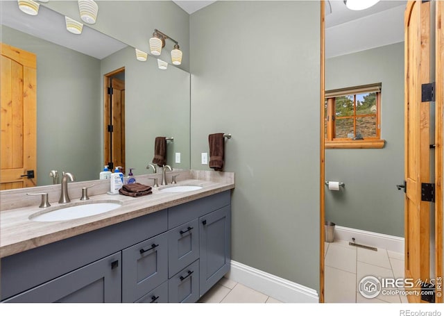 full bath with tile patterned floors, double vanity, and baseboards