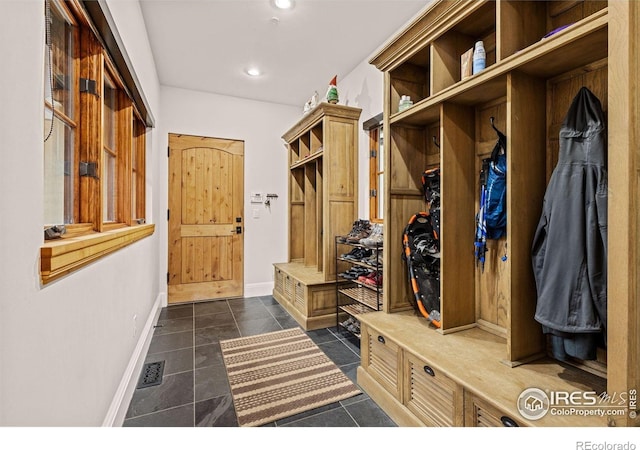 mudroom with baseboards, recessed lighting, and dark tile patterned floors