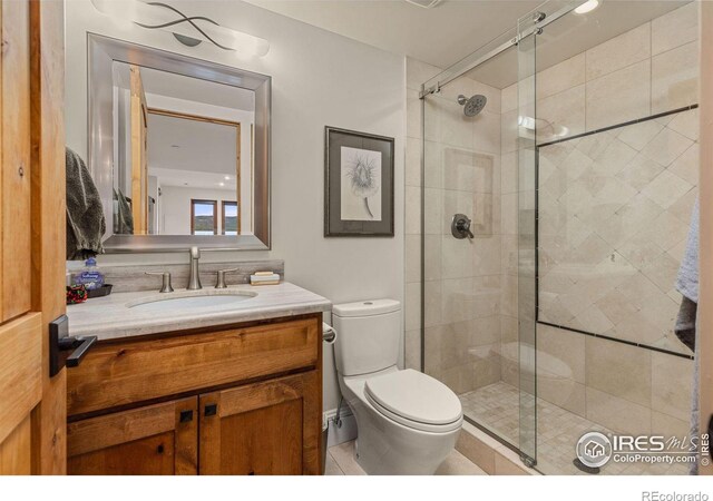 full bath featuring a stall shower, toilet, and vanity