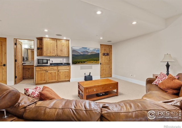 living room with recessed lighting, light carpet, and baseboards