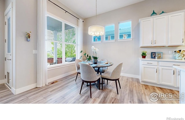 dining space with light wood-style flooring and baseboards