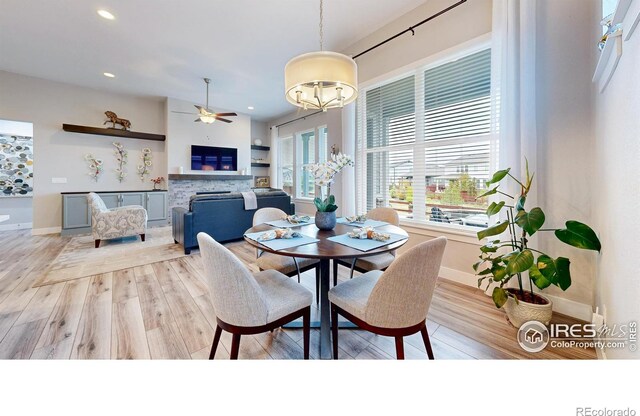 dining space featuring a ceiling fan, light wood-style floors, recessed lighting, baseboards, and a chandelier