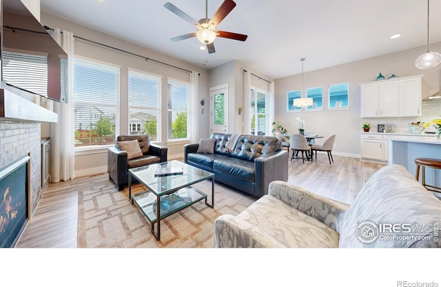 living room featuring light wood-style flooring, healthy amount of natural light, baseboards, ceiling fan, and recessed lighting