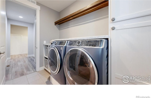 laundry room with washing machine and clothes dryer, baseboards, recessed lighting, light tile patterned floors, and cabinet space