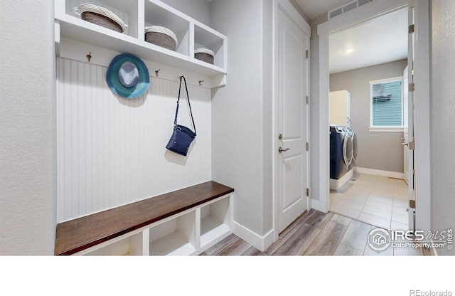 mudroom with independent washer and dryer and baseboards