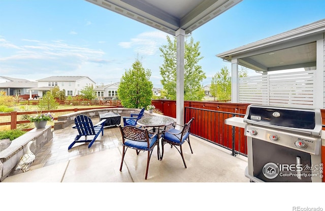 view of patio / terrace featuring area for grilling, fence, a residential view, and outdoor dining area
