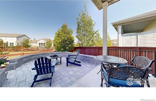 2137 Setting Sun Dr, Windsor, CO 80550 - view of patio with fence, an outdoor fire pit, and outdoor dining space