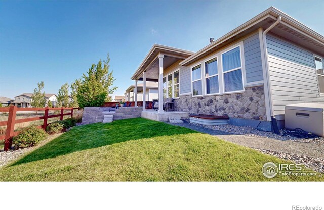 2137 Setting Sun Dr, Windsor, CO 80550 - back of house featuring stone siding